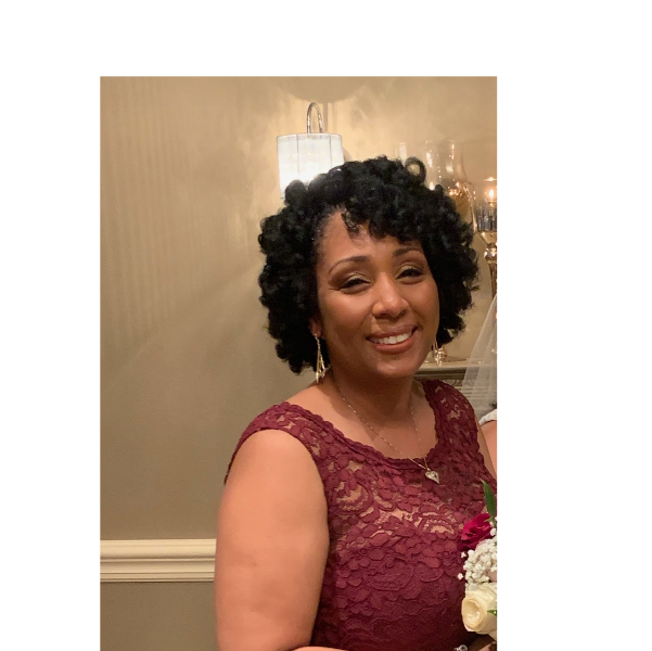 Natural hair styled in a defined roller set with soft bouncy curls.